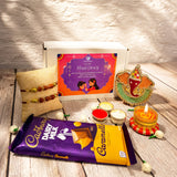 Raksha bandhan gift hamper featuring cadbury dairy milk caramello chocolate bar in purple yellow gold foil packaging