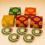 Peacock-shaped tealight holders with green blue and gold embellishments in Diwali gift hamper for festive occasions