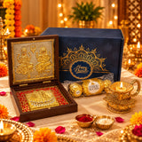 Golden brass diya with intricate floral design and lit candle inside in diwali gift hamper box for festival gifting