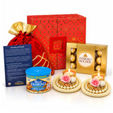Gold ferrero rocher chocolate box with transparent windows in diwali gift hamper featuring ganesha statue and potli bag