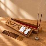 Carved wooden incense box with intricate floral designs red interior holding saffron scented premium incense sticks