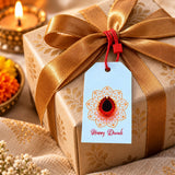 A light blue paper happy diwali gift tag with gold mandala design and red text tied to a golden ribbon bow
