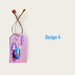 Pink rectangular paper happy diwali gift tag with blue diya design and braided string attached to orange plastic loop