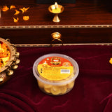 A clear plastic container of golden-yellow divya jyoth pure cow ghee wicks made from butter cotton for puja use