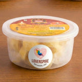 A clear container with yellow and red lid labeled lovenspire michigan usa holds pale yellow pure ghee cotton wicks for pooja