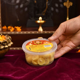 A clear plastic container of round pale yellow pure cow ghee diyas with cotton wicks for puja and temple use