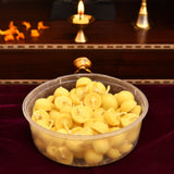 A clear plastic container filled with small round yellow pure cow ghee diyas with cotton wicks for pooja and diwali