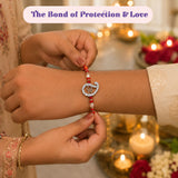 Pure silver om rakhi gift hamper featuring a red and white beaded rakhi with a silver diamond-encrusted g charm