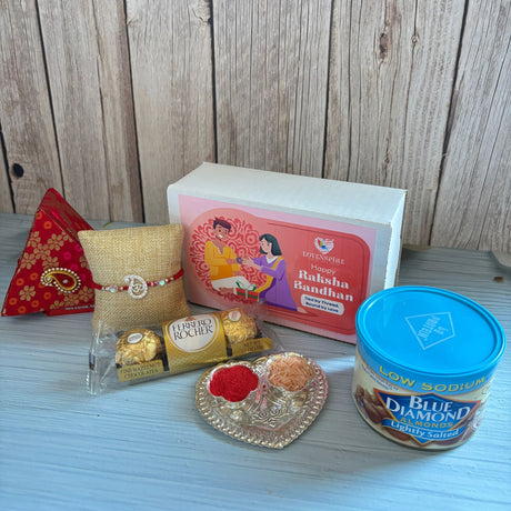 A gold ferrero rocher chocolate pack with intricate design and logo included in pure silver om rakhi gift hamper for brother