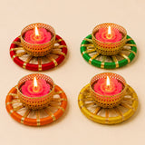 Set of four golden metal tealight candle holders with pink rose wax candles and colorful yarn bases for festive decor