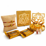Golden ganesha-themed decorative metal tray with intricate cut-out design and lit candle for raksha bandhan gift hamper