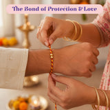 A vibrant orange and yellow twisted thread rakhi with two small golden beads from rakhi gift hamper set for brother and bhabhi