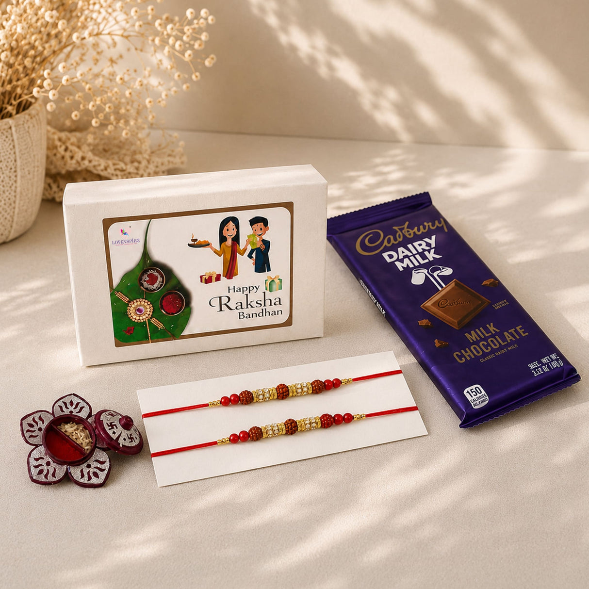 Rakhi gift hamper set with red and gold handmade raksha bandhan bracelet featuring intricate beadwork for brother and bhabhi