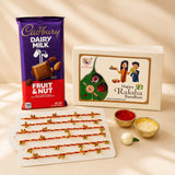 A purple and red cadbury dairy milk fruit and nut chocolate bar in a rakhi gift hamper for brother and bhabhi