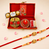 Red and gold brocade rakhi set with ornate golden beads red thread and charms in traditional gift hamper for brother and bhabhi