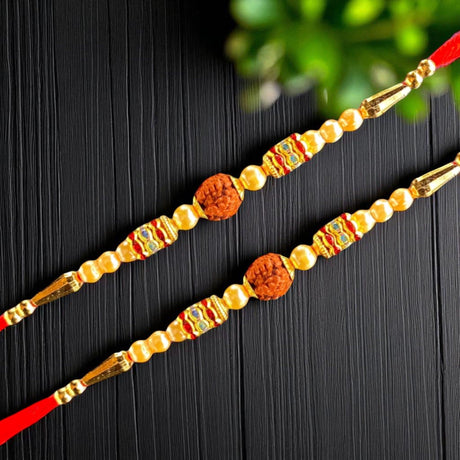 Two ornate Rakhi bracelets displayed in a Raksha Bandhan gift set with decorative accessories