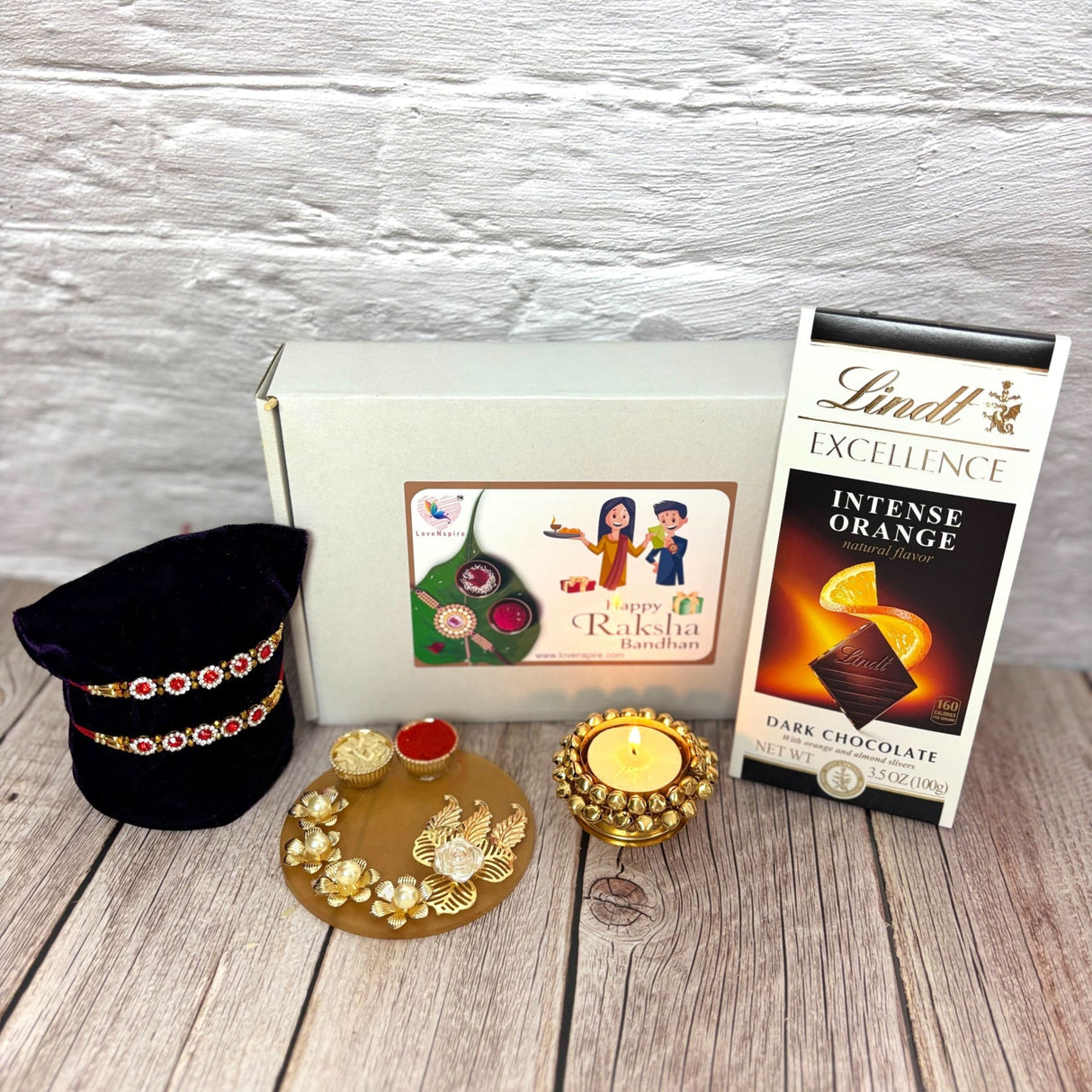 Raksha Bandhan gift set with Rakhis, chocolates, tealight holder, and greeting card