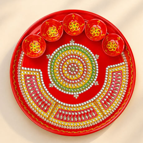 Vibrant red handmade pooja thali with intricate gold green white beadwork and six matching diya bowls for rituals