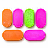 Brightly colored orange pink and green plastic rangoli stencil kit with lotus hands footprints swastikas and sanskrit designs for diwali and puja decor