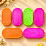 Vibrant orange pink and green oval plastic rangoli stencil kit with embossed lotus footprints swastikas and sanskrit designs