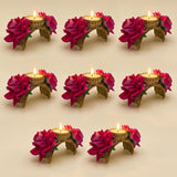 Gold-colored ornate rose tealight candle holders with vibrant pink artificial roses lit for festival decor and gifts