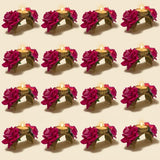 Gold-toned tealight candle holders with intricate floral designs and magenta artificial roses for festive decor