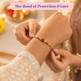 Rudraksha rakhi for bhaiya bhabhi featuring a red and gold bracelet with central rudraksha bead and golden detailing