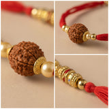 A traditional red and gold rudraksha rakhi bracelet with textured bead and golden pearl accents for raksha bandhan