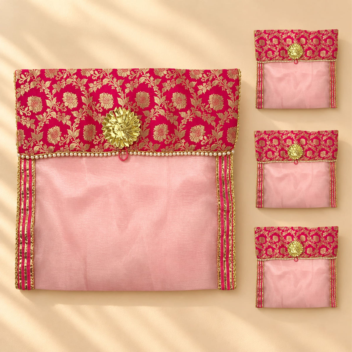 A vibrant pink and gold embroidered fabric saree cover with button closure and decorative golden flower clasp for storage
