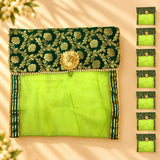 Emerald green and gold embroidered fabric saree cover pouch with central floral embellishment for storage and travel