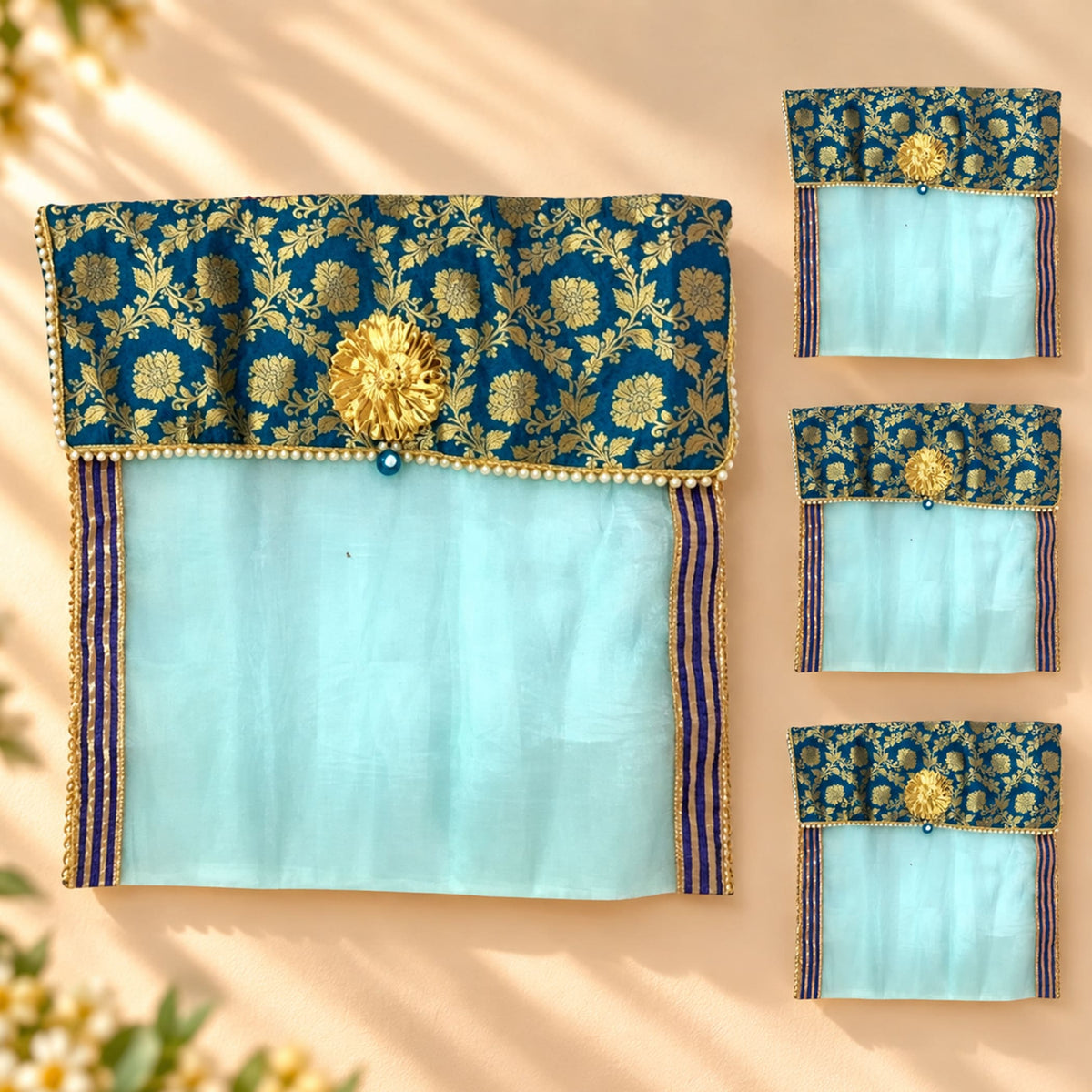 Blue and gold embroidered fabric saree cover with central golden floral embellishment and pearl bead trim for wardrobe storage