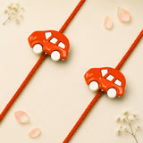 Cute cartoon car rakhi bracelet with bright orange toy car charms on red braided cords for brother protection gift