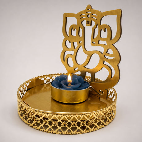 Golden metal Shadow Ganesha tea light candle holder with intricate cutout design and blue rose tealight for Diwali decor