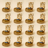 Golden ganesha-themed tea light candle holders with intricate cut-out designs and ornate patterned bases for diwali decor