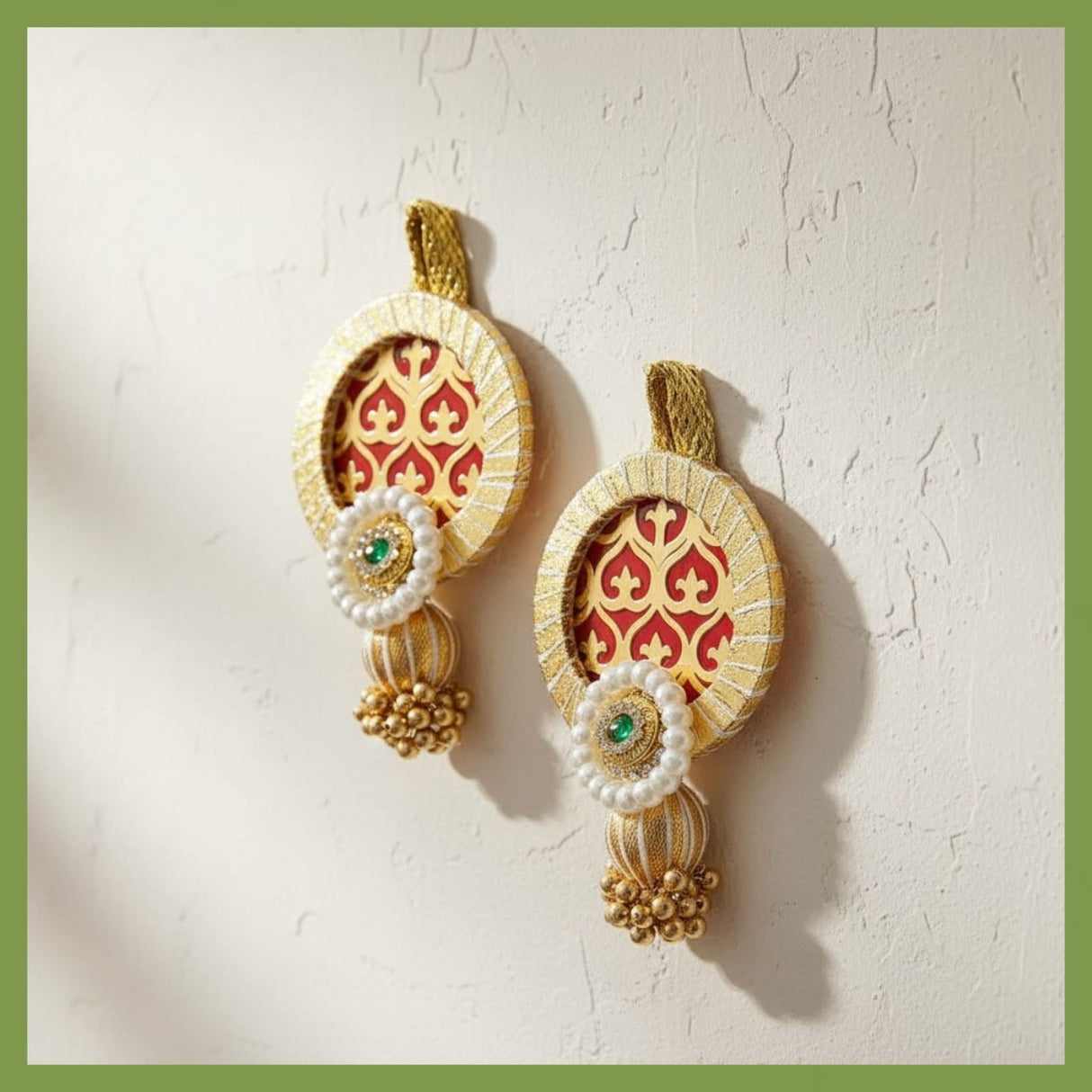 Ornate gold and red wall hangings with pearls and emerald accents for Indian decor