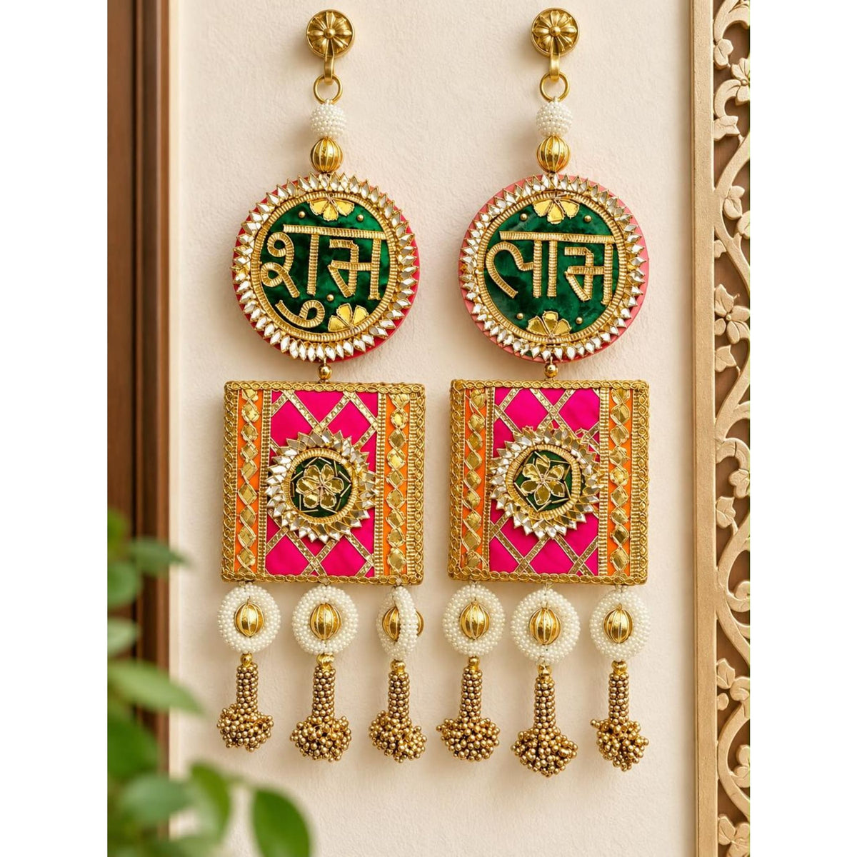 Vibrant green and pink embroidered circular earrings with gold floral patterns and beaded tassels for festive decor