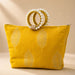 A vibrant yellow silk handbag with silver leaf embroidery and pearl-adorned woven handles for Eid and wedding favors