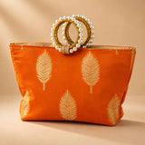 Orange satin silk tote bag with gold leaf embroidery and pearl adorned golden handles for Eid and wedding favors