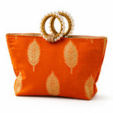 Eid gift orangish-orange silk handbag with gold leaf embroidery and pearl adorned golden handles for wedding and Diwali favors