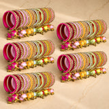 A vibrant collection of pink gold and pastel handcrafted silk thread bangles with kundan and elephant charms for weddings