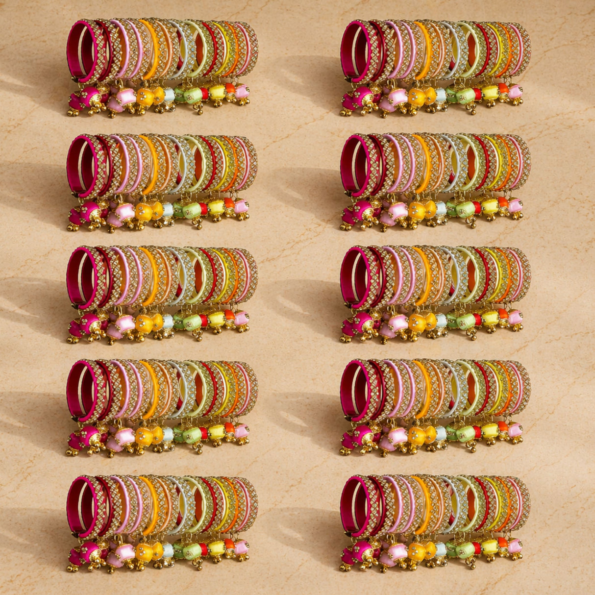 A set of colorful silk thread bangles with gold-tone kundan embellishments and dangling beads for indian weddings