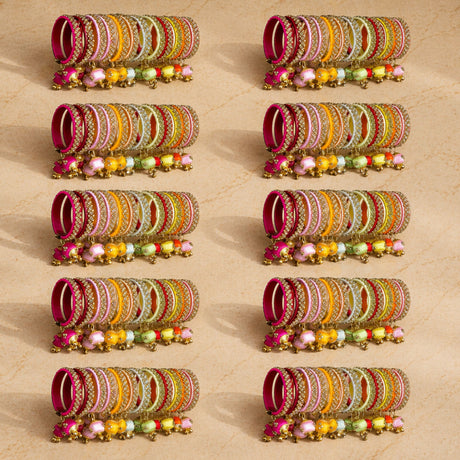 A set of colorful silk thread bangles with gold-tone kundan embellishments and dangling beads for indian weddings