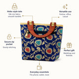 A vibrant blue hobo-style silk-mix tote bag with gold red and teal floral embroidery and wooden handles for festive occasions