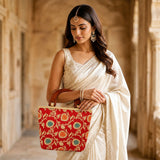 Traditional Indian embroidered red silk handbag with gold and teal floral patterns and wooden handles for festive occasions