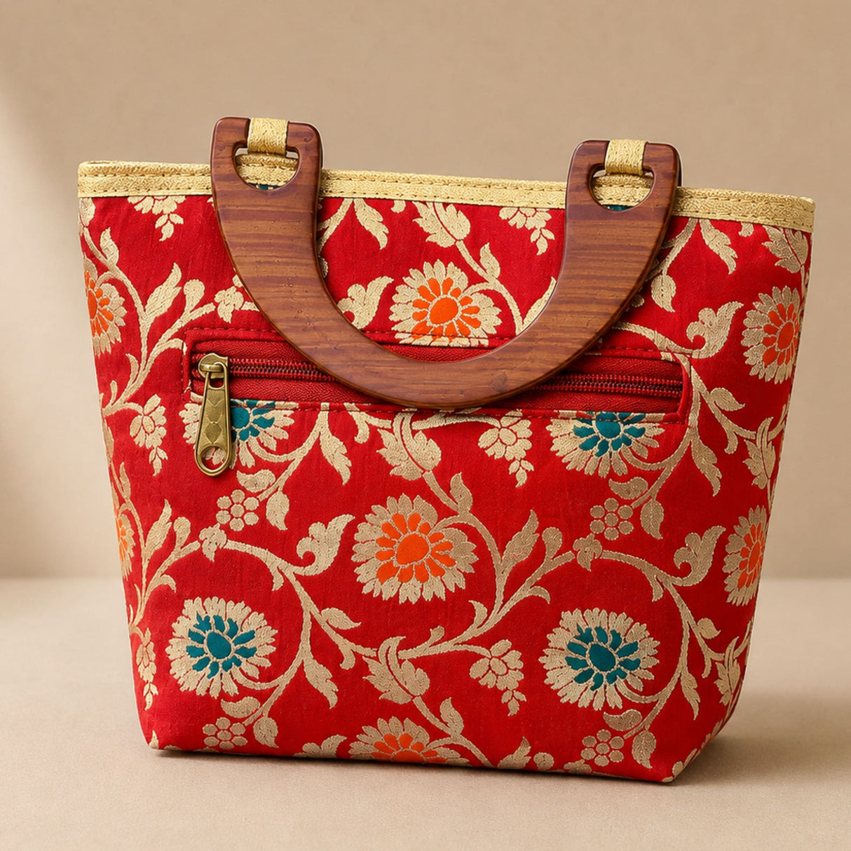 Red silk handbag with intricate gold and teal floral embroidery and wooden handles for traditional Indian festivals