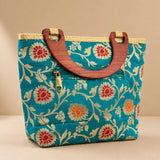 Traditional Indian embroidered teal silk handbag with floral pattern wooden handles and gold-tone zipper for festivals