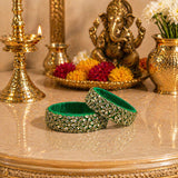 Emerald green indian silk thread bangles with intricate silver-toned floral patterns and sparkling rhinestones for bridal gifts