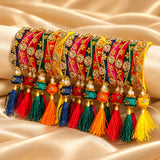 A vibrant set of silk thread bangles with kundan-style work in pink red yellow and green for weddings and festivals