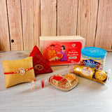 Gold-colored heart-shaped brass tray with red and orange powders for pure silver ganesha rakhi gift hamper for brother