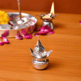 Silver plated mini mangal kalash with silver lotus shaped diya having reflective metallic finish and embossed petals